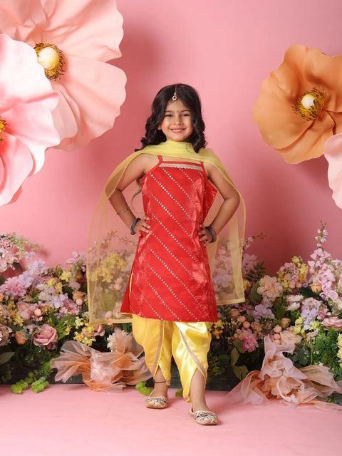 Young girl in a red and yellow traditional outfit standing against a pink background with flowers.