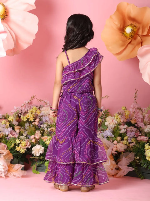 Person wearing a purple outfit with floral decorations and flowers in the background
