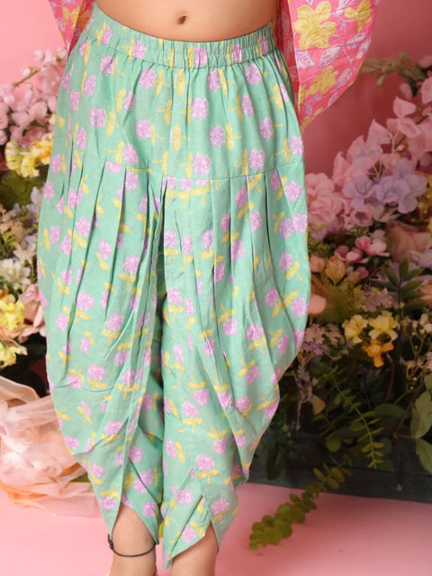 Green floral-patterned pants worn by a person with a pink background