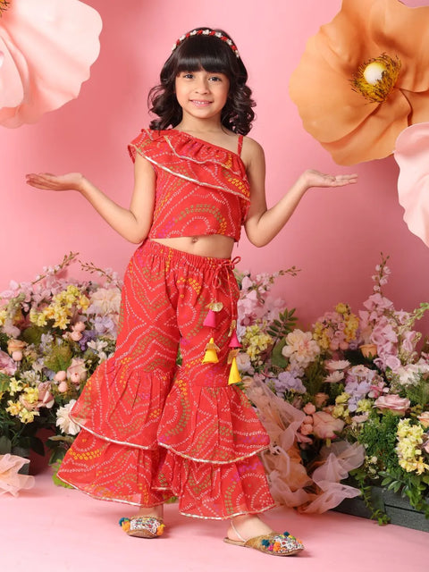 Young girl in a red outfit with floral decorations against a pink background