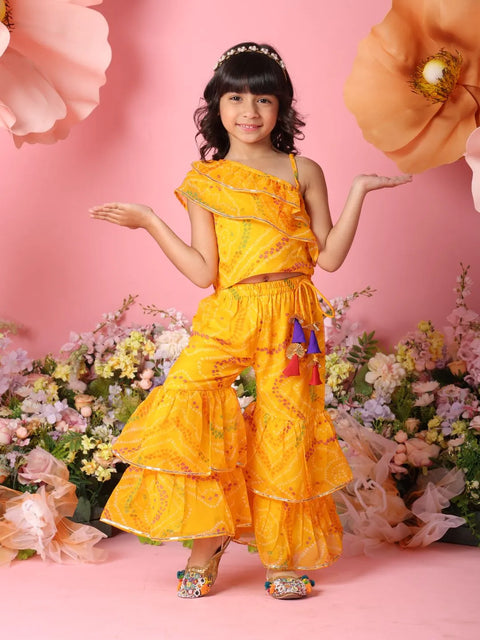 Young girl in a yellow outfit with floral decorations on a pink background