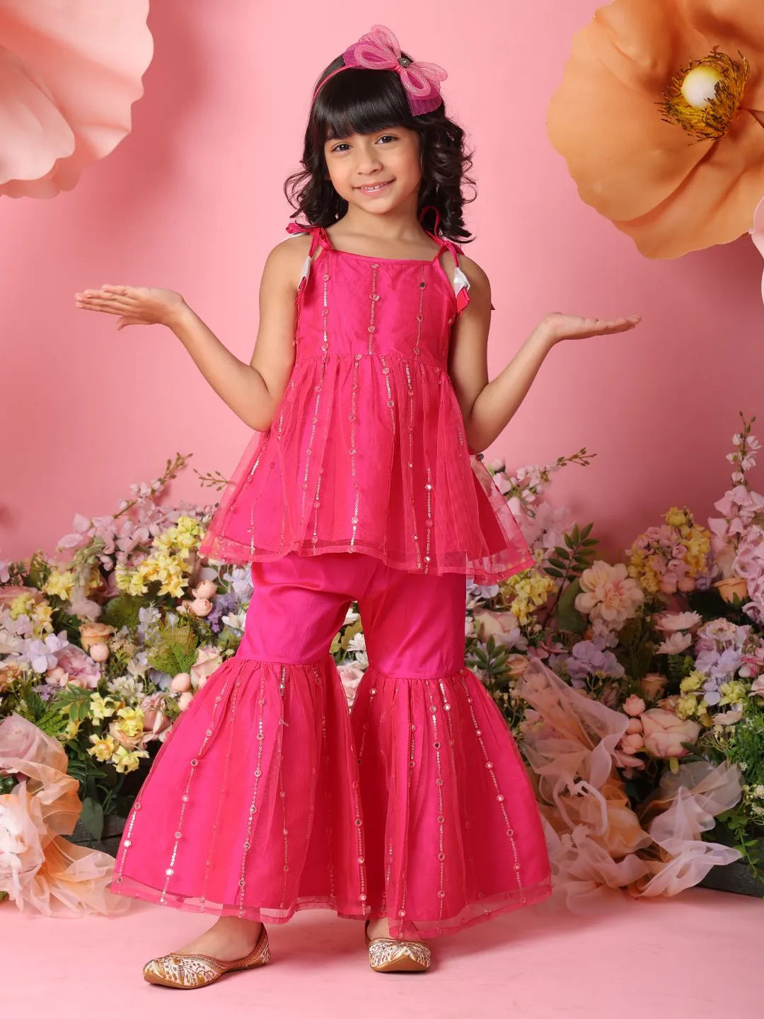 Young girl in a pink outfit with flowers and a pink background
