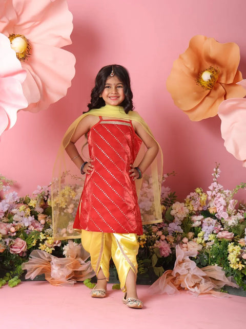 Young girl in a red and yellow traditional outfit standing against a pink floral background
