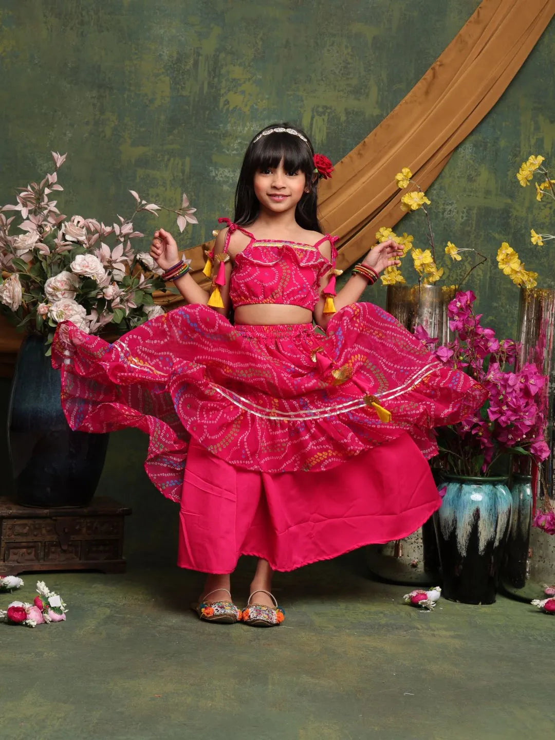 Young girl in a bright pink traditional outfit with flowers and decorative elements.