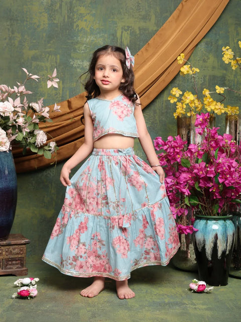 Young girl in a floral dress standing in a decorated room with flowers and decorative elements.