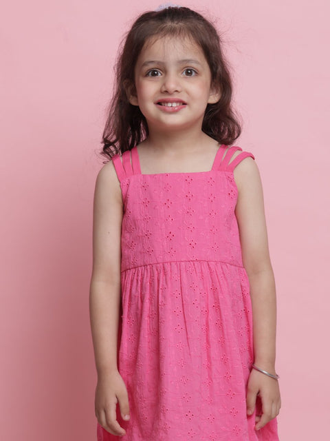 Young girl wearing a pink dress against a pink background