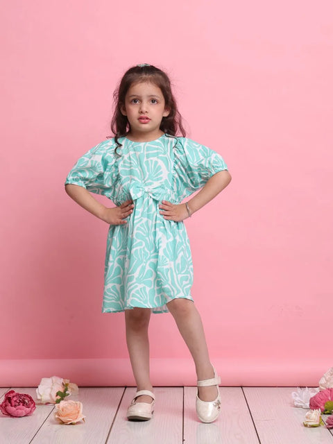 Young girl wearing a light blue dress with a floral pattern against a pink background