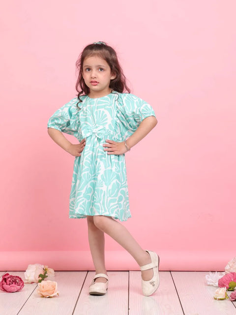 Young girl wearing a light blue dress with a floral pattern against a pink background