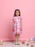 Young girl wearing a floral dress against a pink background