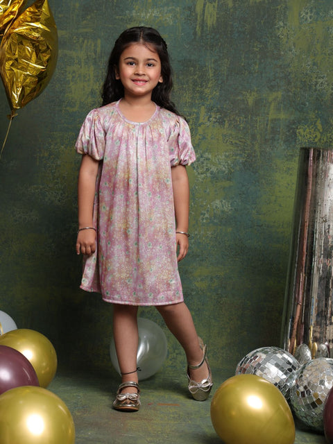 Young girl in a floral dress standing among balloons with a textured green wall background