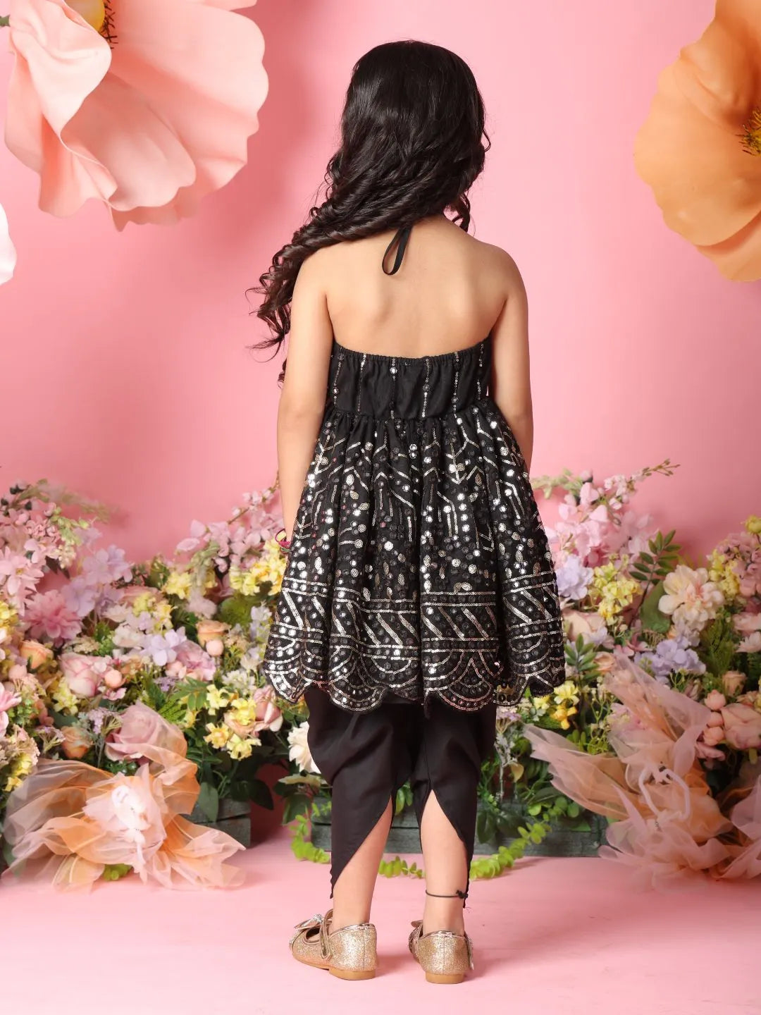 Woman wearing a black and white patterned dress with a floral background