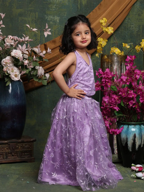 Young girl in a purple dress standing among flowers with a decorative background