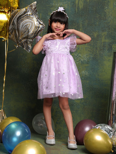 Young girl in a purple dress posing with balloons against a green wall