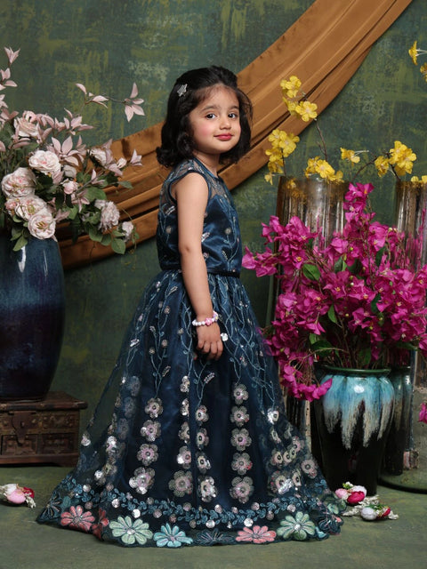 Young girl in a floral dress standing among flowers with a decorative background