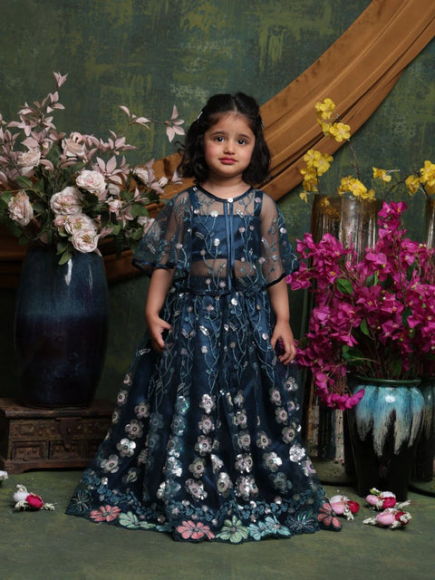 Young girl in a dark blue floral dress standing among flowers with a decorative background