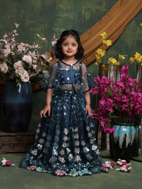 Young girl in a floral dress standing among flowers with a decorative background