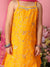 Person wearing a yellow dress with floral patterns against a pink background