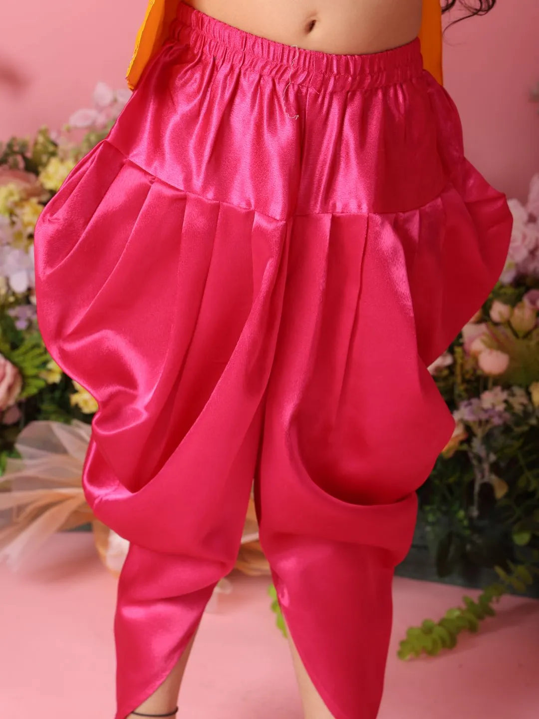 Red satin harem pants with a blurred floral background