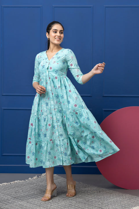 Woman wearing a light blue floral dress against a blue wall.