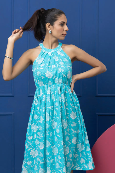 Woman wearing a turquoise floral dress against a blue background