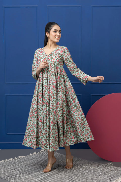 Woman wearing a floral dress against a blue wall with a red circular object.