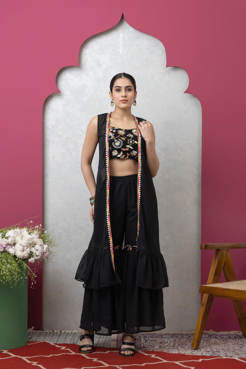 Woman in a black traditional outfit with a pink wall and decorative elements