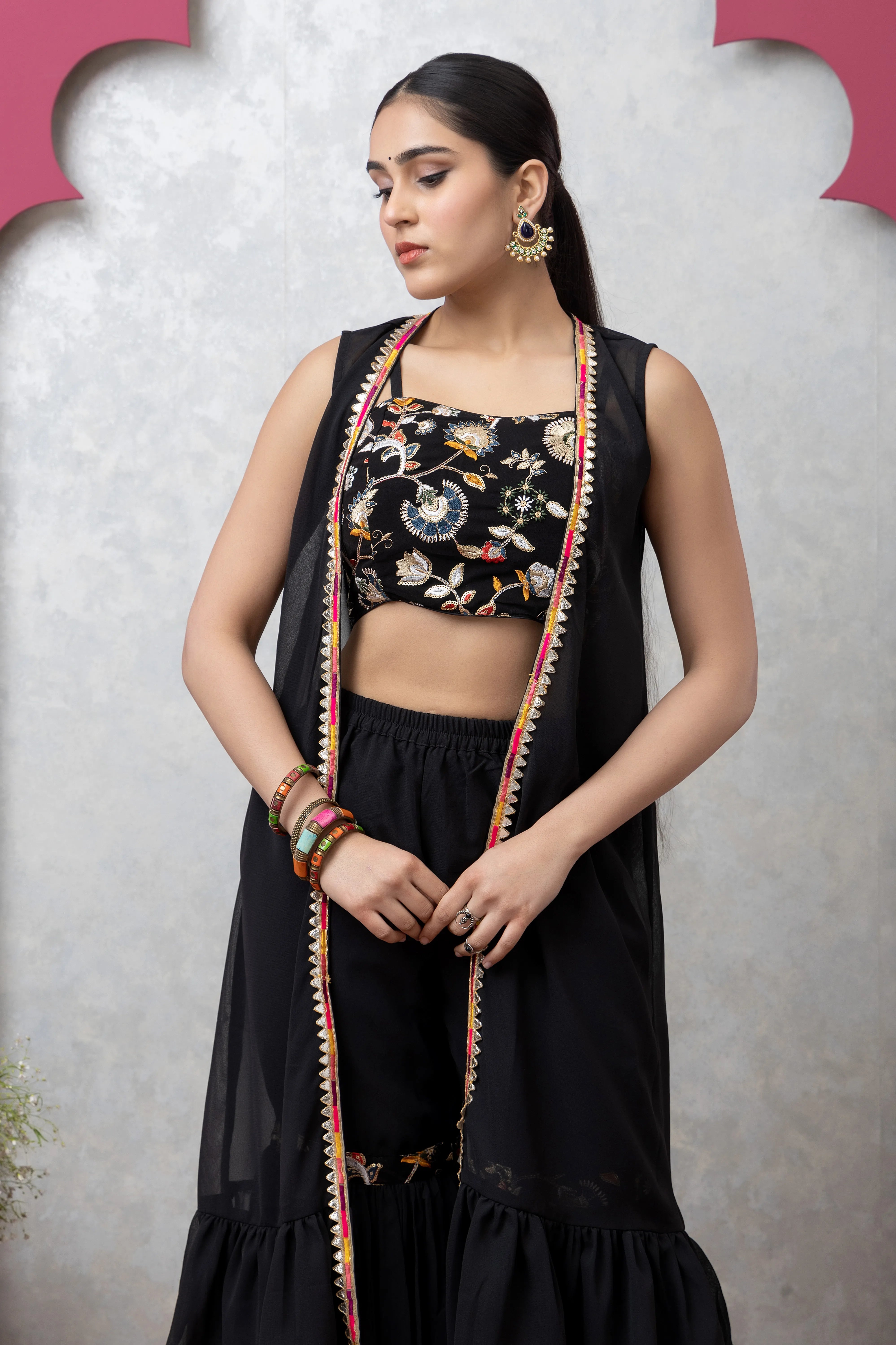 Woman wearing a black outfit with floral patterns against a light gray background