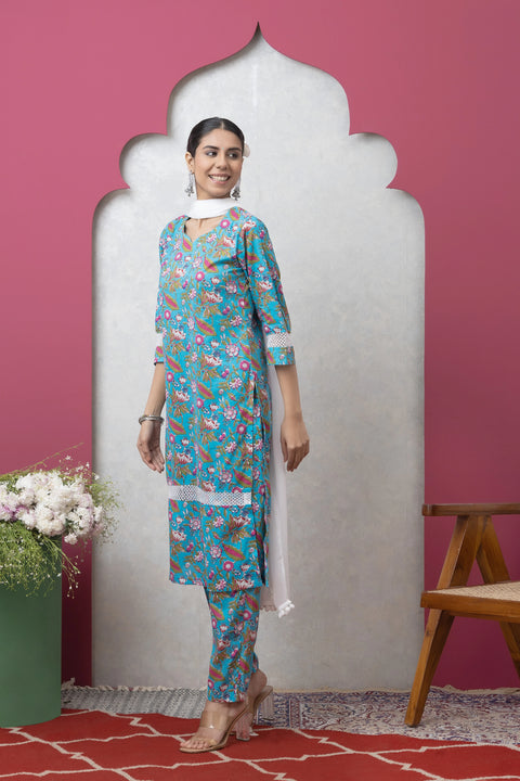 Woman wearing a floral dress standing against a pink wall with a decorative arch.