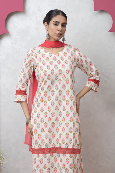 Woman wearing a white and red patterned kurta with a red dupatta against a gray background