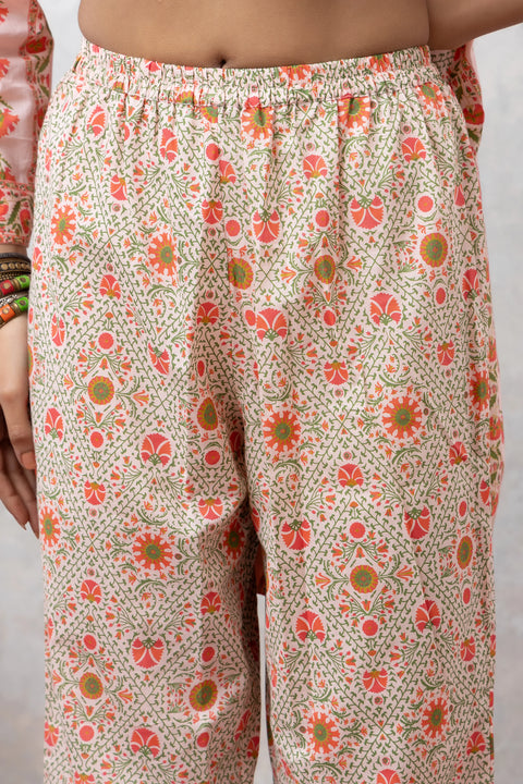 Floral patterned pants worn by a person on a plain background