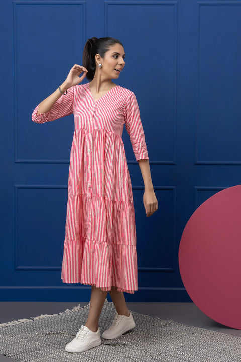 Woman wearing a pink dress with a blue wall and pink ball in the background
