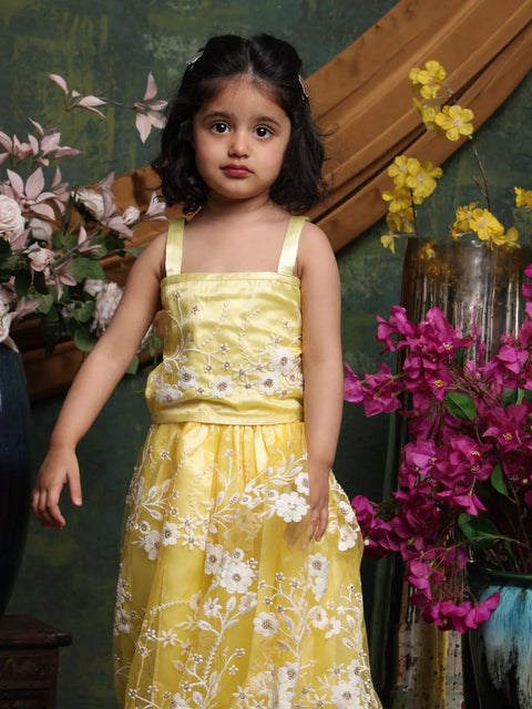Young girl in a yellow dress standing among flowers