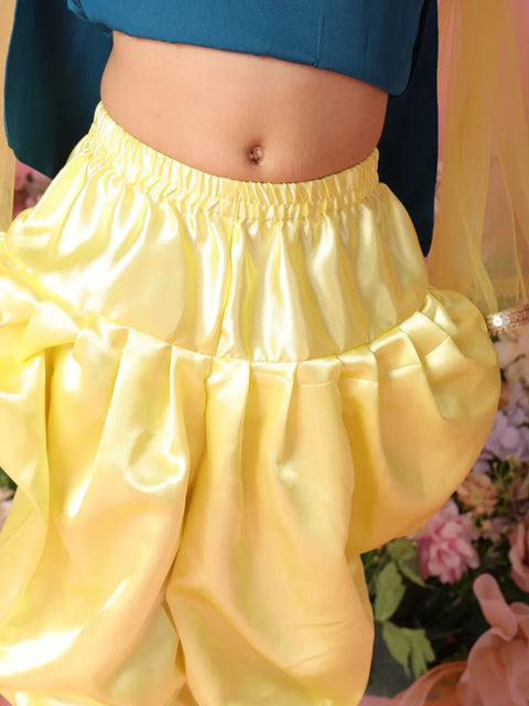 Yellow pants with a blue top worn by a person, with a blurred background.