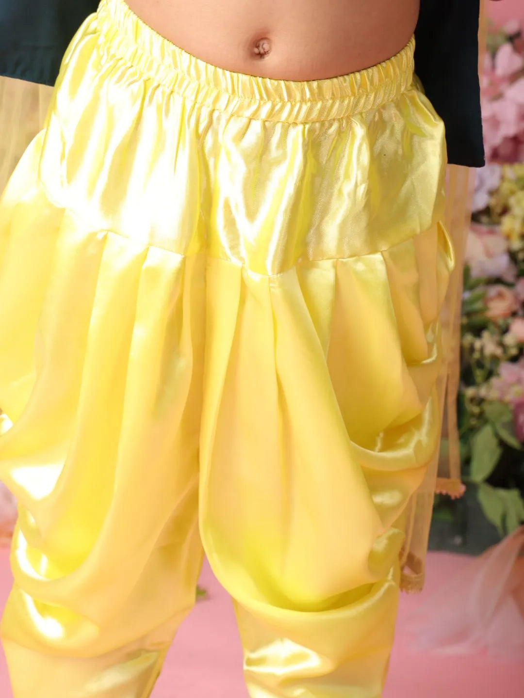 Yellow shiny pants worn by a person with a blurred background