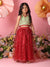 Young girl in a green top and red skirt standing in front of flowers with a pink background