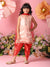 Young girl in a pink and red traditional outfit standing against a pink background with flowers.