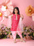Young girl in a pink traditional outfit with flowers and decorations in the background