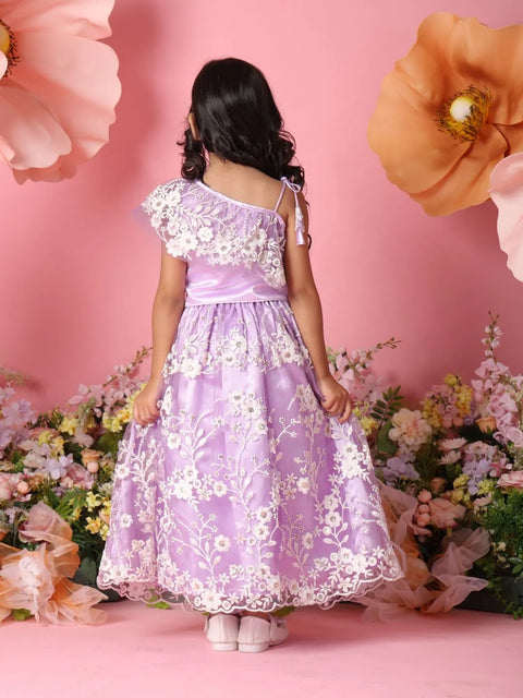 Young girl in a purple floral dress standing against a pink background with flowers.