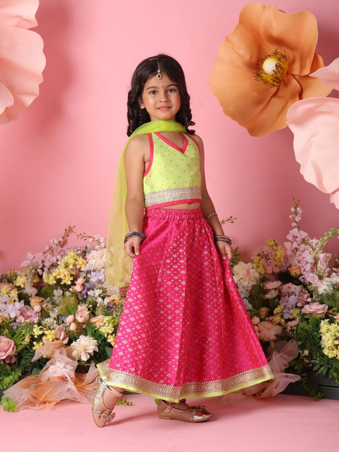 Young girl in a traditional outfit with flowers and pink background