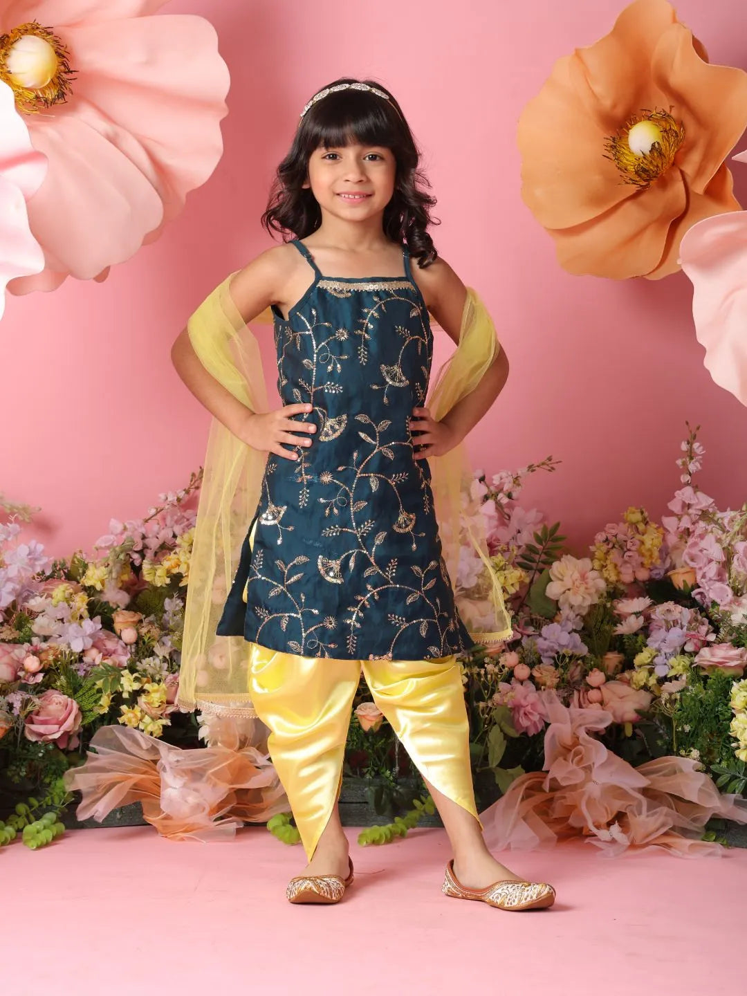Young girl in traditional outfit with floral decorations and pink background